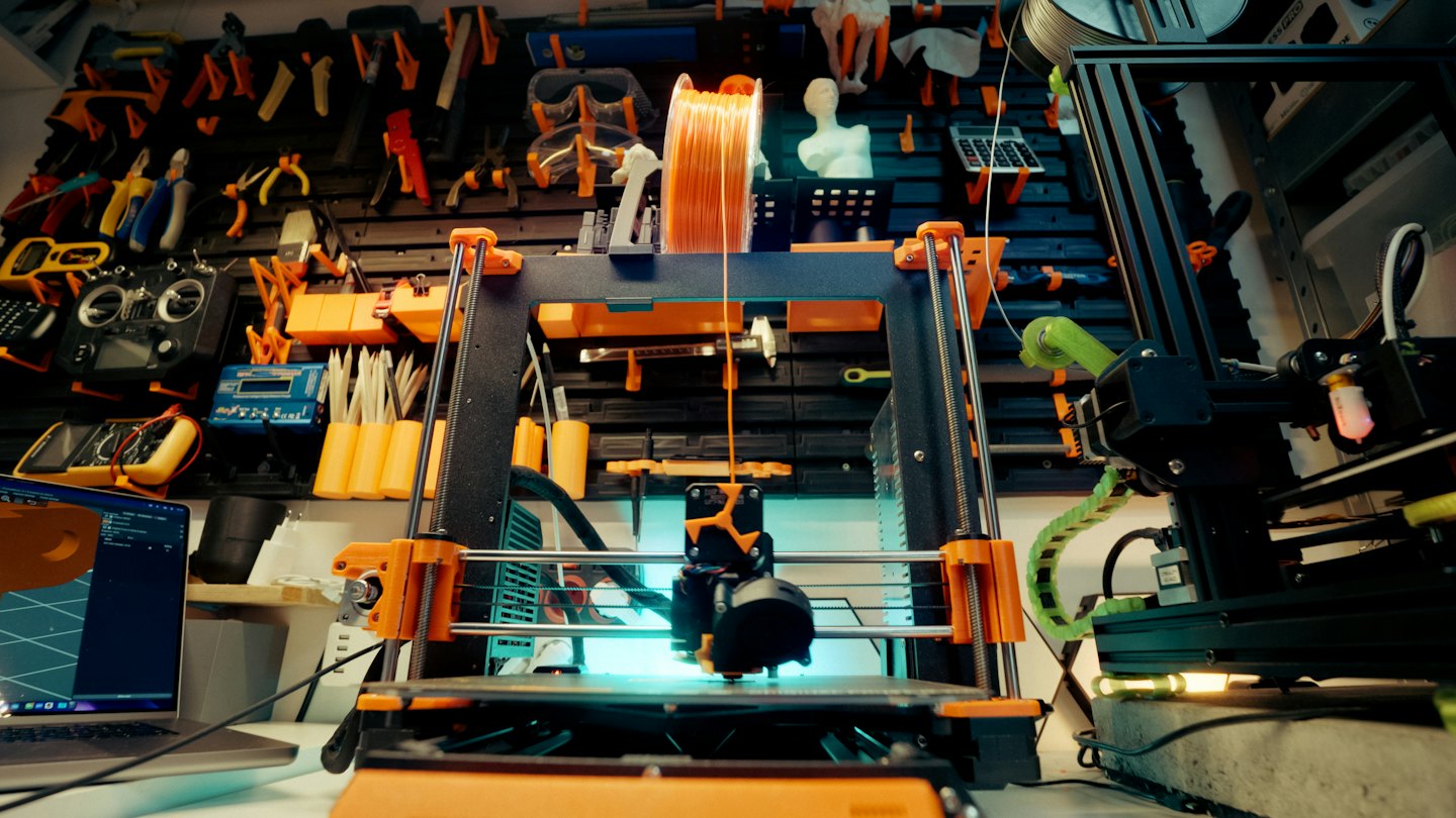 3D tlačiareň vytvára objekt z oranžovej priadze.